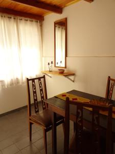 comedor con mesa, sillas y ventana en Del Valle Apartamentos 285 en Valle Hermoso