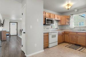 a kitchen with wooden cabinets and a white stove top oven at Pet Friendly 2 King Beds Foosball Table in Rapid City