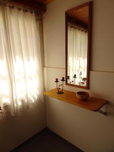 Habitación con espejo y ventana con flores en un estante en Del Valle Apartamentos 285 en Valle Hermoso