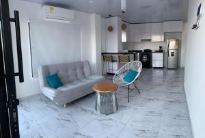 a living room with a couch and a table and a kitchen at Casita Madrigal in Santa Verónica
