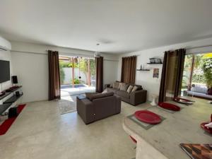 a living room with a couch and a tv at La Réserve Design Villas in Pipa