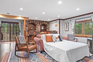 a bedroom with a bed and chairs and a fireplace at Tatanka Hideaway Hot Tub Pool Table Massive Space in Custer
