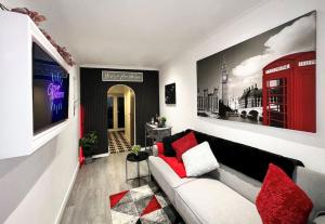 a living room with a white couch and a red phone booth at Boutique Backyard Bungalow - Brimsdown in Enfield Lock