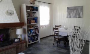 ein Wohnzimmer mit einem Tisch und einem Bücherregal in der Unterkunft VILLA KANTOUNI ON THE BEACH in Panormos Kalymnos