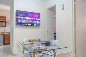 トゥルムにあるCozy Tulum Oasis: 2-Bedroom w/ Poolのダイニングテーブル(椅子付)、壁掛けテレビ