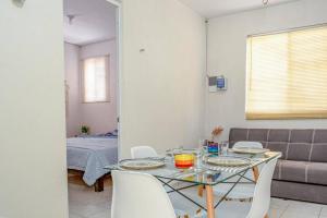 トゥルムにあるCozy Tulum Oasis: 2-Bedroom w/ Poolのガラスのテーブルと白い椅子のあるダイニングルーム