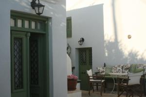 a room with a green door and a table and chairs at Matsas Mansions in Chora Folegandros +64 photos
