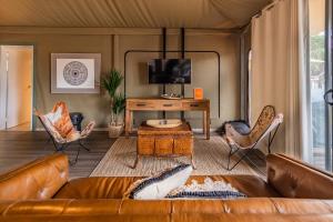 a living room with a brown couch and chairs at NRMA Broulee Holiday park in Broulee