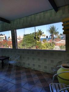 a room with two windows and a table and chairs at Pousada Porto Seguro in Porto De Galinhas