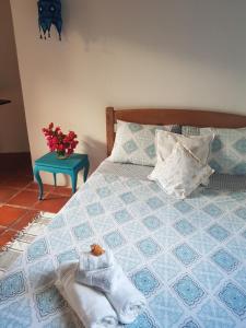 a bedroom with a bed with towels and a table at Chalé Flor do Ser in Canoa Quebrada