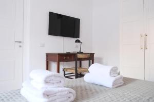 ein Zimmer mit weißen Handtüchern auf dem Boden und einem Schreibtisch in der Unterkunft Ventisei in Catania
