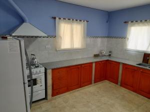 a kitchen with red cabinets and a white stove top oven at La Glorieta -Casas de descanso in San Salvador de Jujuy