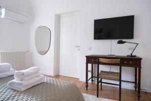 - une chambre avec un bureau, une télévision et une chaise dans l'établissement Ventisei, à Catane