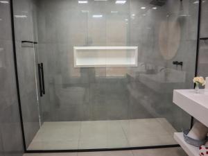 a shower with a glass door in a bathroom at Pousada Gata Russa in Saco do Ceu