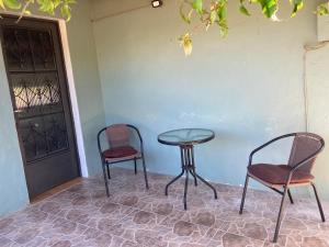 duas cadeiras e uma mesa ao lado de uma porta em Las Margaritas em La Coronilla