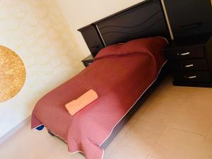 a bed with a red blanket and a wooden headboard at DIAMEZ HOTEL PLAZA in Sacaba