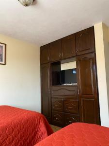 克薩爾特南戈的住宿－Apartamento #4 Portal de Occidente，一间卧室设有大型木制橱柜和一张床