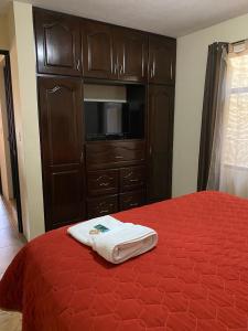 a bedroom with a bed and a cabinet with a towel on it at Apartamento #4 Portal de Occidente in Quetzaltenango