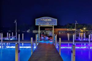 a person sitting on a dock at a marina at night at Lakes Region Gem - Chic Victorian Apt - Laconia in Laconia