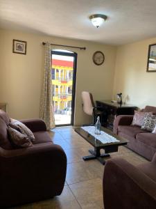 a living room with two couches and a table at Apartamento #4 Portal de Occidente in Quetzaltenango