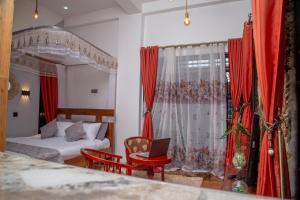 1 dormitorio con cama y cortina roja en Green Villa Apartments en Kampala