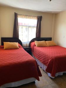 a room with two beds and a window at Apartamento #4 Portal de Occidente in Quetzaltenango