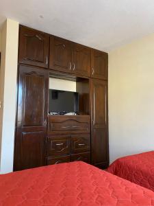 Un dormitorio con un gran armario de madera y una cama en Apartamento #3 Portal de Occidente, en Quetzaltenango