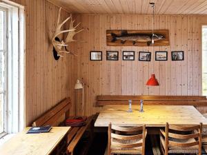 uma sala de jantar com uma mesa de madeira e algumas fotografias na parede em Holiday home MALUNG em Malung