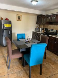 cocina con mesa, sillas y nevera en Apartamento #6 Portal de Occidente en Quetzaltenango