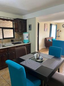 uma cozinha e sala de jantar com uma mesa e cadeiras azuis em Apartamento #6 Portal de Occidente em Quetzaltenango
