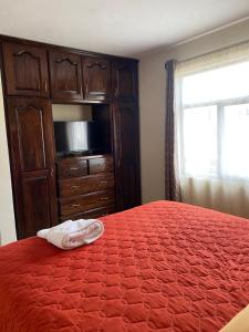 ein Schlafzimmer mit einem Bett und eine Kommode mit einem Handtuch darauf in der Unterkunft Apartamento #6 Portal de Occidente in Quetzaltenango