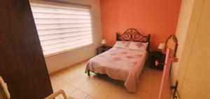 a small bedroom with a bed and a window at Departamento Shejiná in Tarija