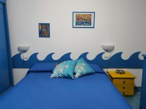 a bedroom with a blue bed with a wave painted on the wall at Casa Rossella in Procida