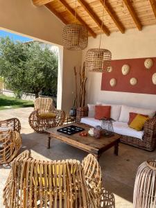 a living room with rattan furniture and a table at Le Mas Saint Philippe in Jonquières