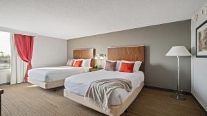 a hotel room with two beds and a window at 315 LoSo Hotel Airport in Charlotte