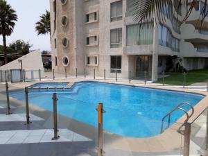 a swimming pool in front of a building at La Serena Sol y Mar in La Serena