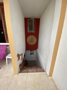 uma escada com uma parede vermelha e branca e um piso em Luna Roja casa Frente al Mar y glamping em San Onofre
