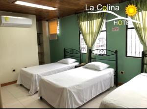 two beds in a room with a hotel at Hotel la colina in Cartago