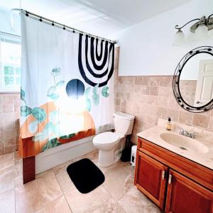 a bathroom with a toilet and a shower curtain at 7 Arches in Hill View