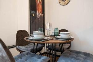 a dining room table with chairs and a clock on the wall at Lewes Guest Nest in Lewes