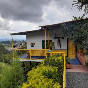 a yellow and white house with a balcony at Finca Cardonales in Salento