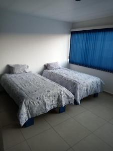 dwa łóżka siedzące obok siebie w sypialni w obiekcie Casa Ejecutiva en Gran Jardin w mieście León