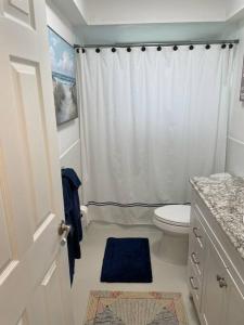 a bathroom with a white shower curtain and a toilet at The Flip Flop - UPDATED vacation home! in Naples