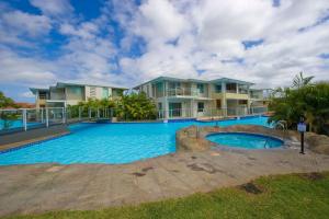 a large swimming pool in front of some houses at Pacific Blue 520 private pool air conditioning and Wi Fi in Salamander Bay