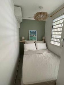 a small bedroom with a bed in the corner at Kay Agapi - Apt T3 sur la plage - Diamant in Le Diamant
