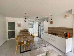 a kitchen with a wooden table and a counter top at Kay Agapi - Apt T3 sur la plage - Diamant in Le Diamant
