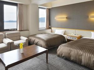 Postel nebo postele na pokoji v ubytování Miyajima Coral Hotel