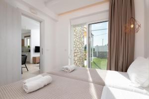 a bedroom with a bed with two towels on it at Ossiano Pool Villas,Heating Pool, 2 min drive to Haraki Beach & 10 min to Lindos in Haraki