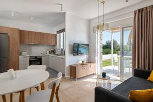a kitchen and a living room with a table and a couch at New Brand Villas, Heating Pool , Jacuzzi , Spa near beach with children area,2 min drive, beach, tavern,market in Haraki