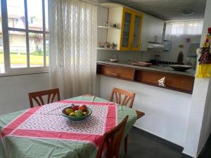 a kitchen with a table with a bowl of fruit on it at condomínio Porto di Mare Casa 22 ALAGOAS in Paripueira